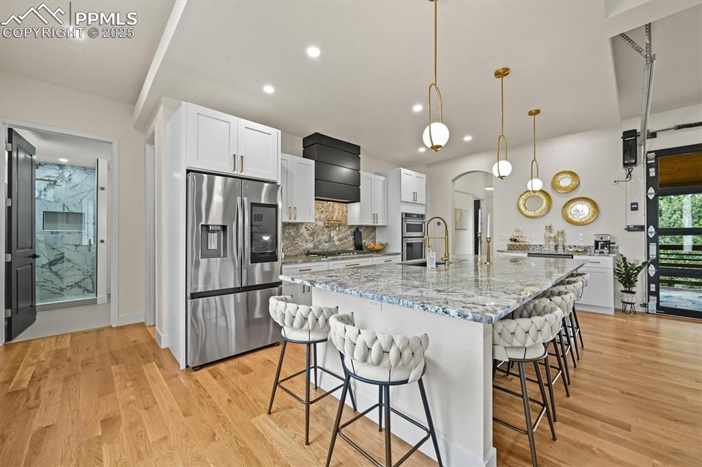 Image 8 of 47: Kitchen featuring white cabinets, appliances with stainless steel finishes,