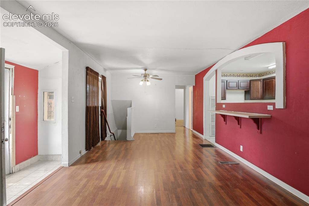 Image 12 of 36: SPACIOUS LIVING AREA FEATURING BUILT-IN SHELVING AND A BREAKFAST-BAR PASS-T