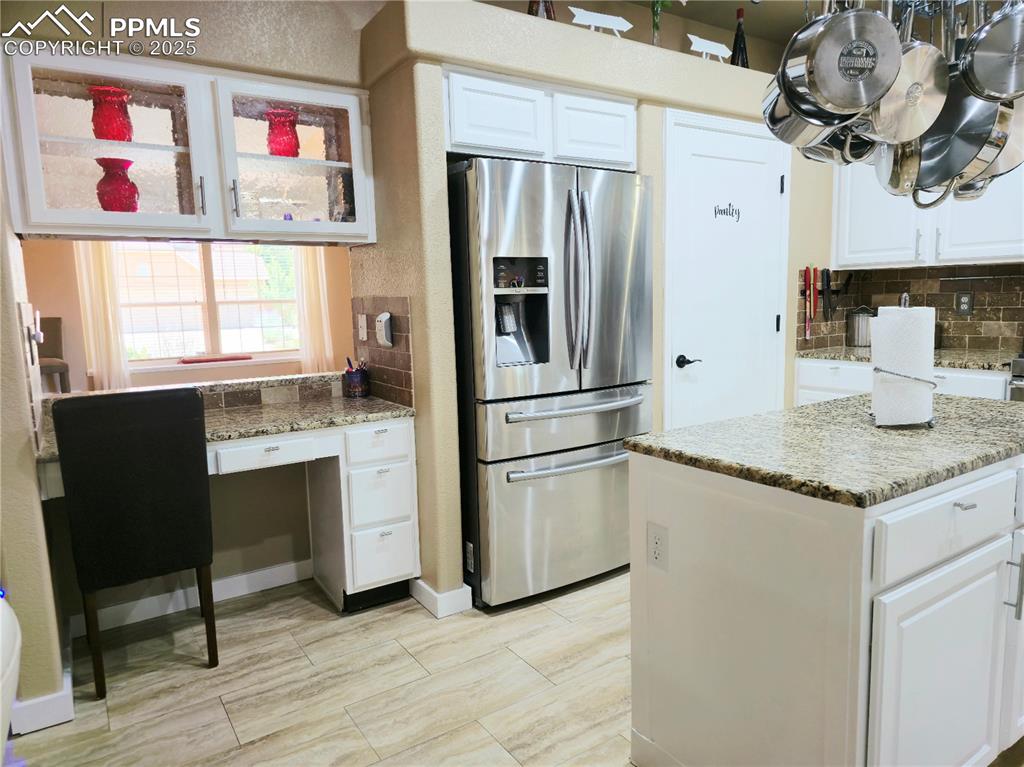 Image 10 of 48: Kitchen with stainless steel appliances, tasteful backsplash, white cabinet