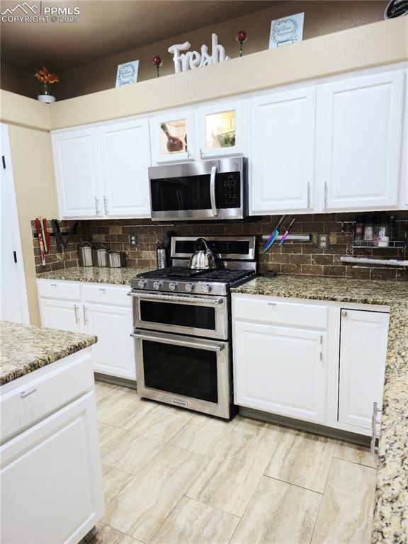 Image 11 of 48: Kitchen with stainless steel refrigerator with ice dispenser, backsplash, b