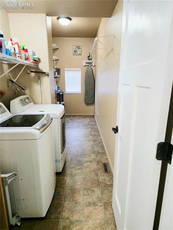 Image 20 of 48: guest Bathroom main level with washing machine and dryer, vanity, wood fini
