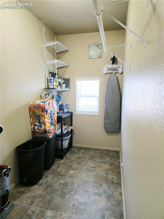 Image 21 of 48: Laundry room with washer and clothes dryer and stone finish flooring