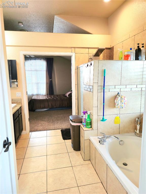 Image 34 of 48: Bedroom with french doors, carpet floors, vaulted ceiling, and ensuite bath