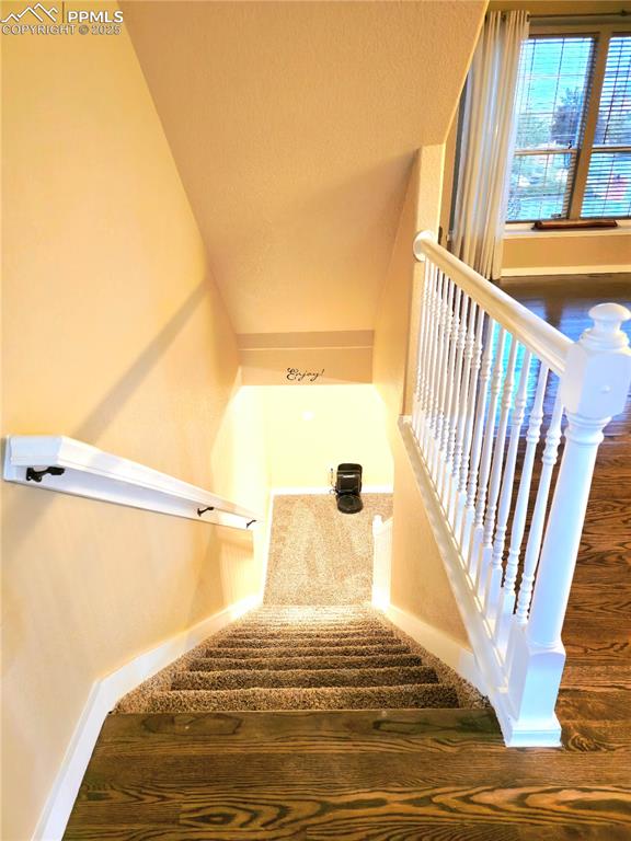 Image 38 of 48: Stairway with carpet and a textured wall