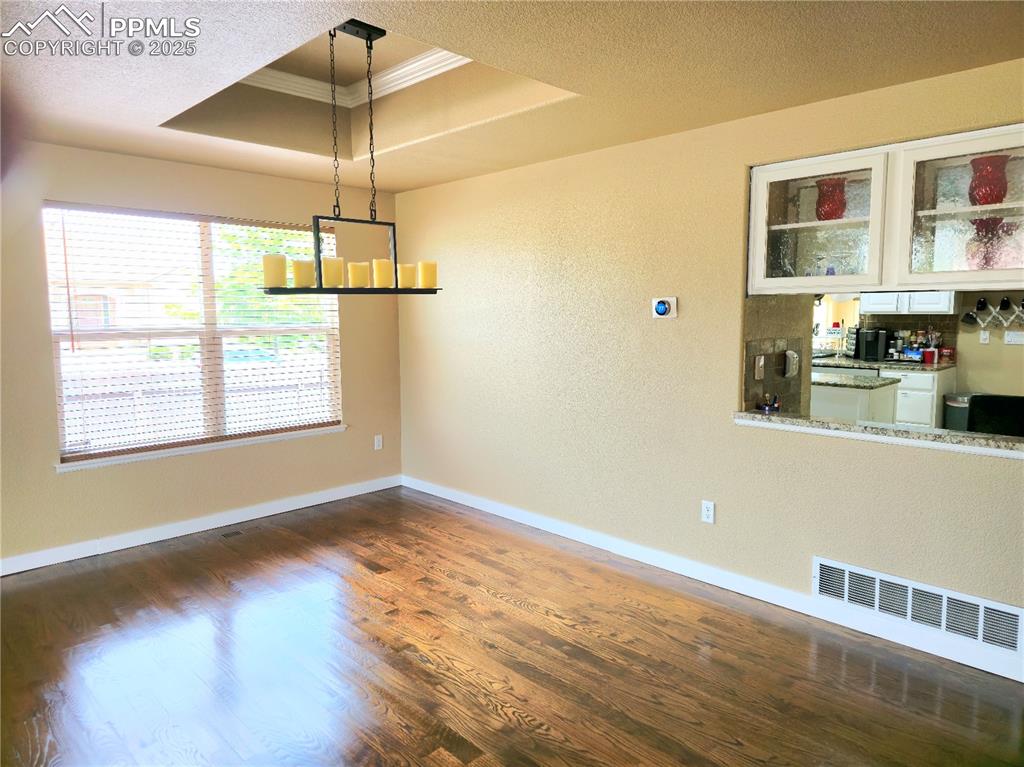 Image 5 of 48: Unfurnished living room with crown molding, wood finished floors, and stair