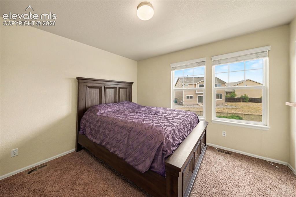 Image 18 of 24: Secondary spacious guest bedroom on upper level