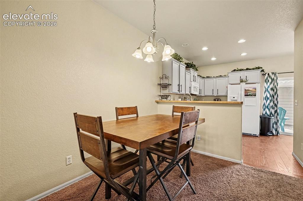 Image 8 of 24: Separate dining area along with a bar that would accommodate bar stools for