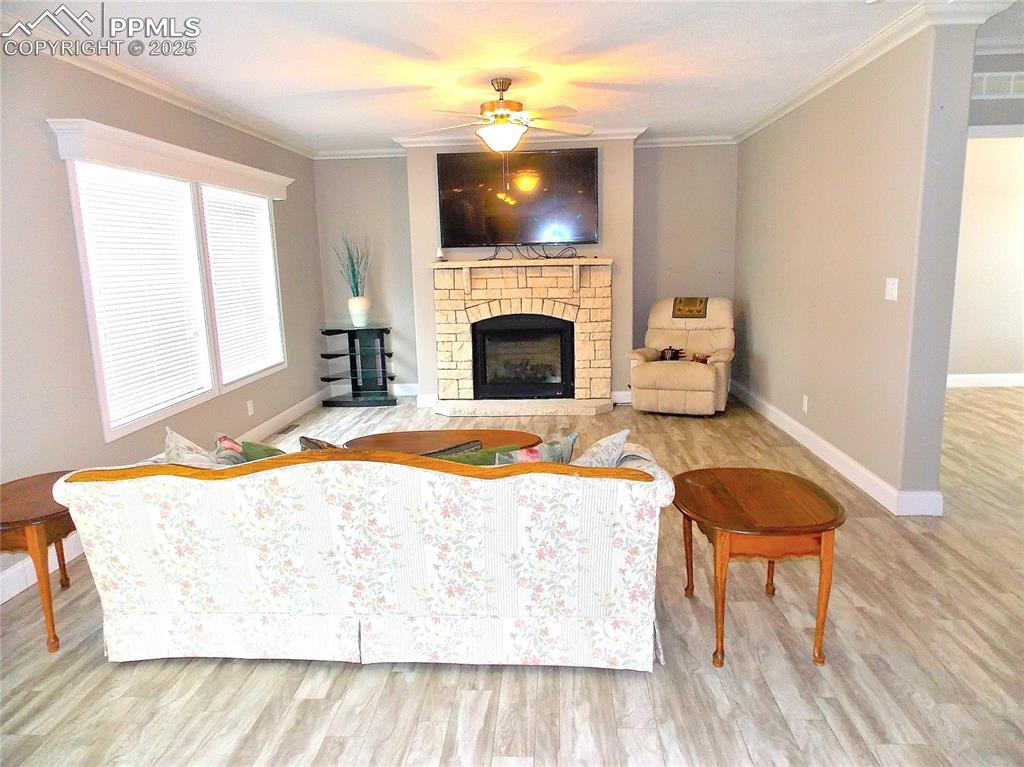 Image 12 of 33: Living room featuring a brick fireplace, light hardwood / wood-style floori