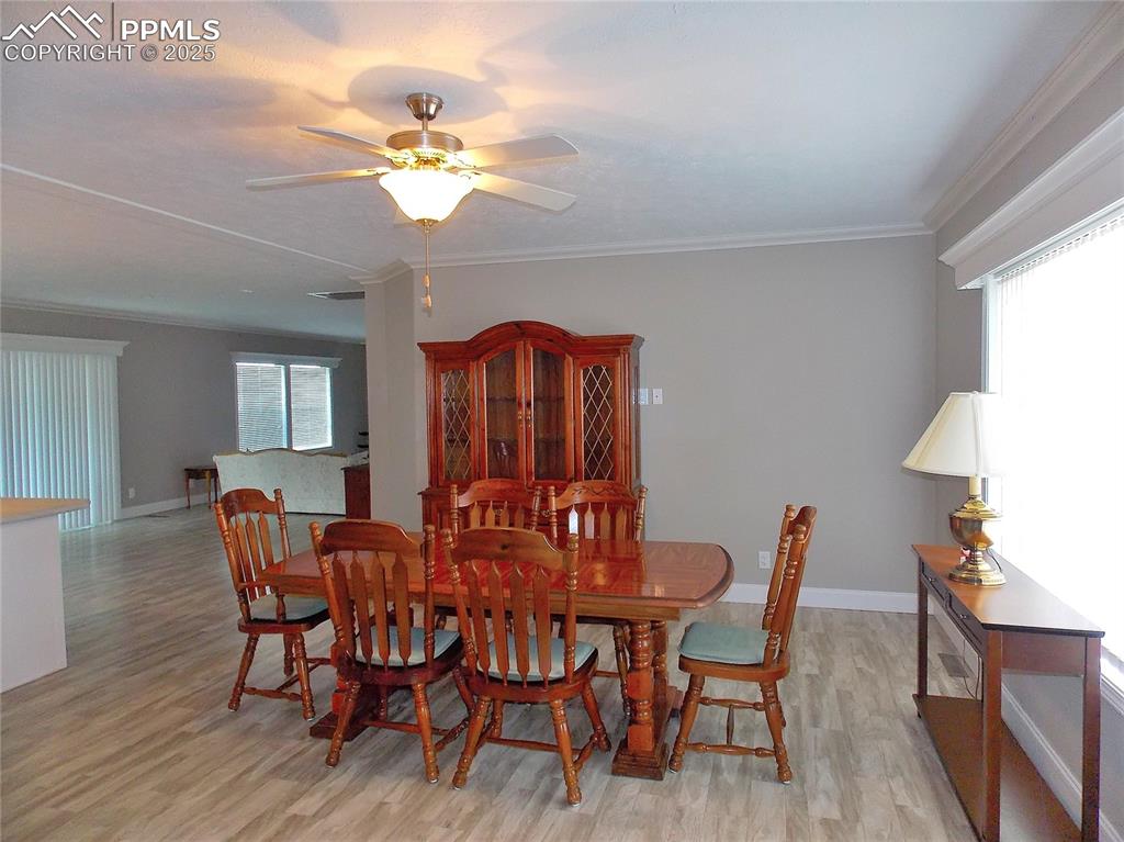 Image 5 of 33: Dining room featuring ceiling fan, light, crown molding, and picture window
