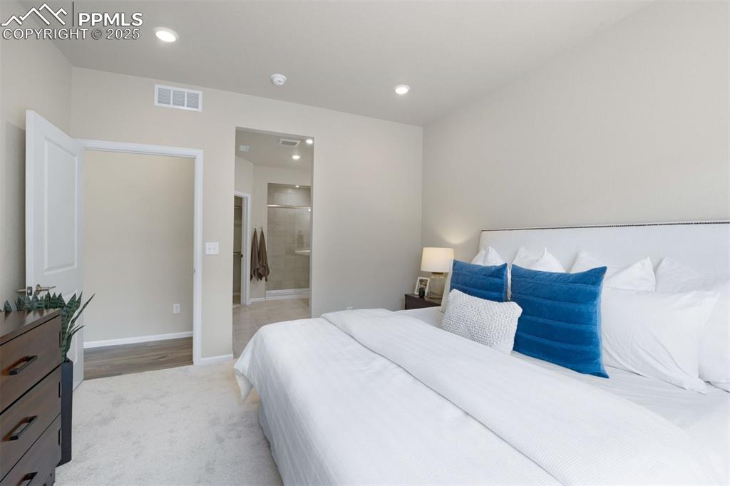 Image 24 of 28: Bedroom featuring recessed lighting, ensuite bathroom, and light carpet