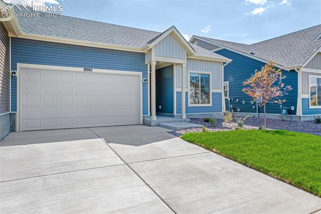 Image 3 of 28: Ranch-style home featuring roof with shingles, a front lawn, driveway, a ga