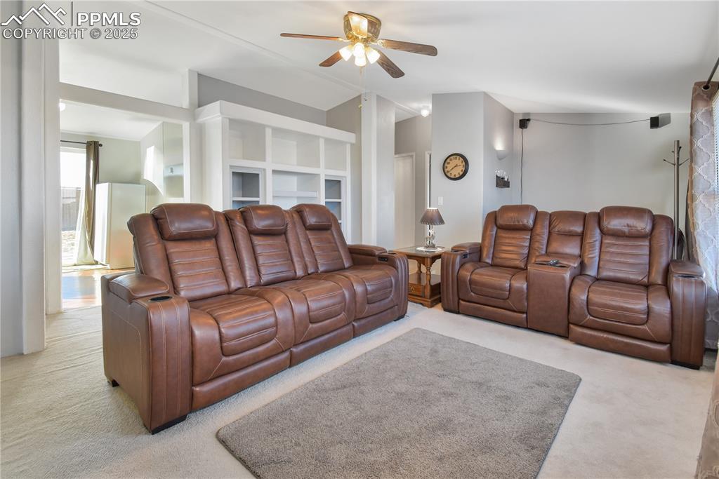 Image 12 of 34: Carpeted living area with a ceiling fan