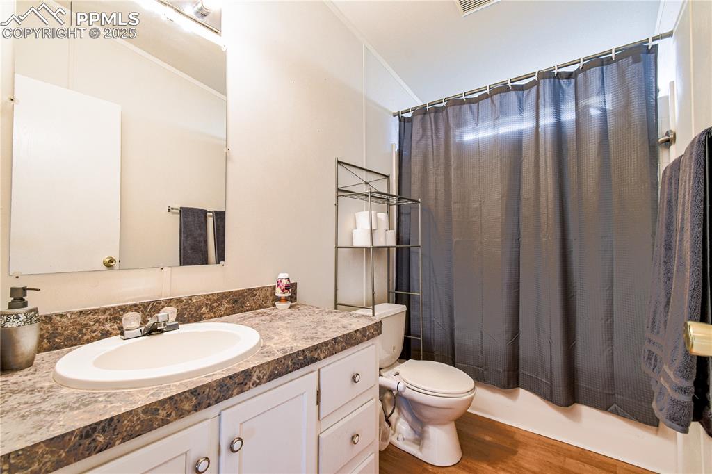 Image 20 of 34: Bathroom with dark wood-style flooring, vanity, shower / bathtub combinatio