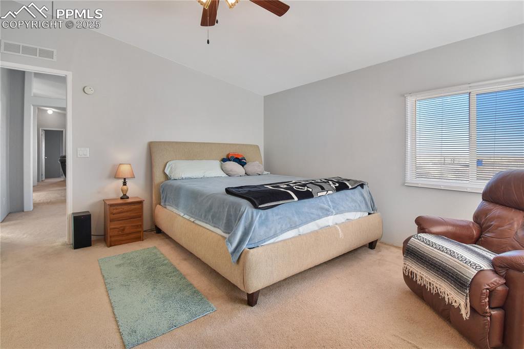 Image 25 of 34: Carpeted bedroom featuring a ceiling fan and vaulted ceiling
