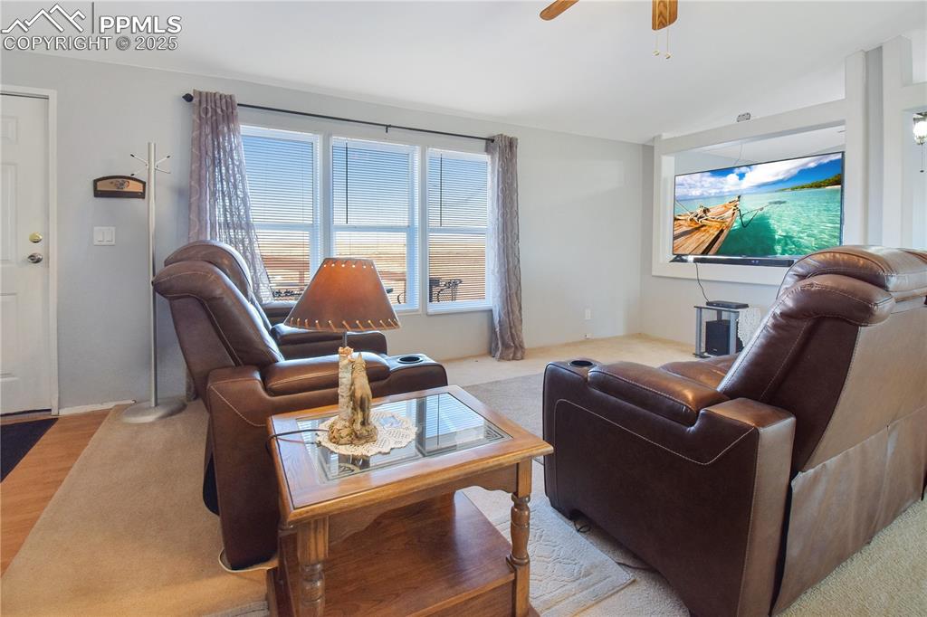 Image 9 of 34: Carpeted living room featuring a ceiling fan