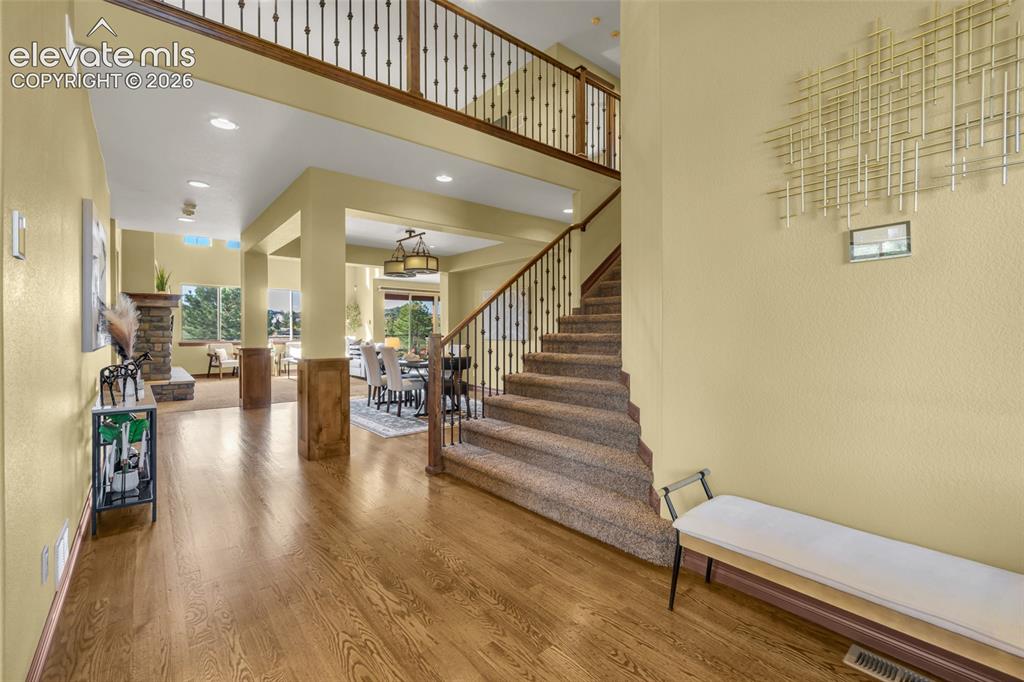 Image 20 of 50: Foyer featuring wood-finish flooring, a two-story ceiling, a staircase with