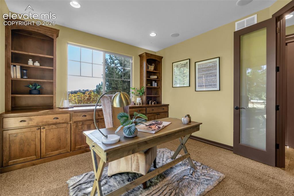 Image 21 of 50: Built-in wooden cabinetry with shelving, recessed lighting, and a glass-pan