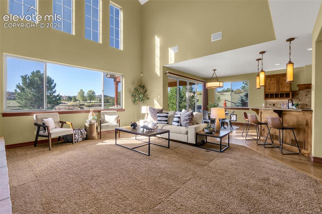 Image 25 of 50: Expansive open-concept living area featuring vaulted ceilings, large multi-