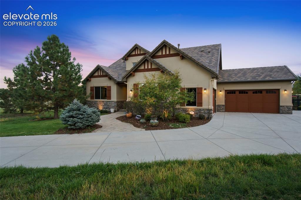 Image 3 of 50: Stucco and stone exterior featuring multiple gables, wood-finish shutters,