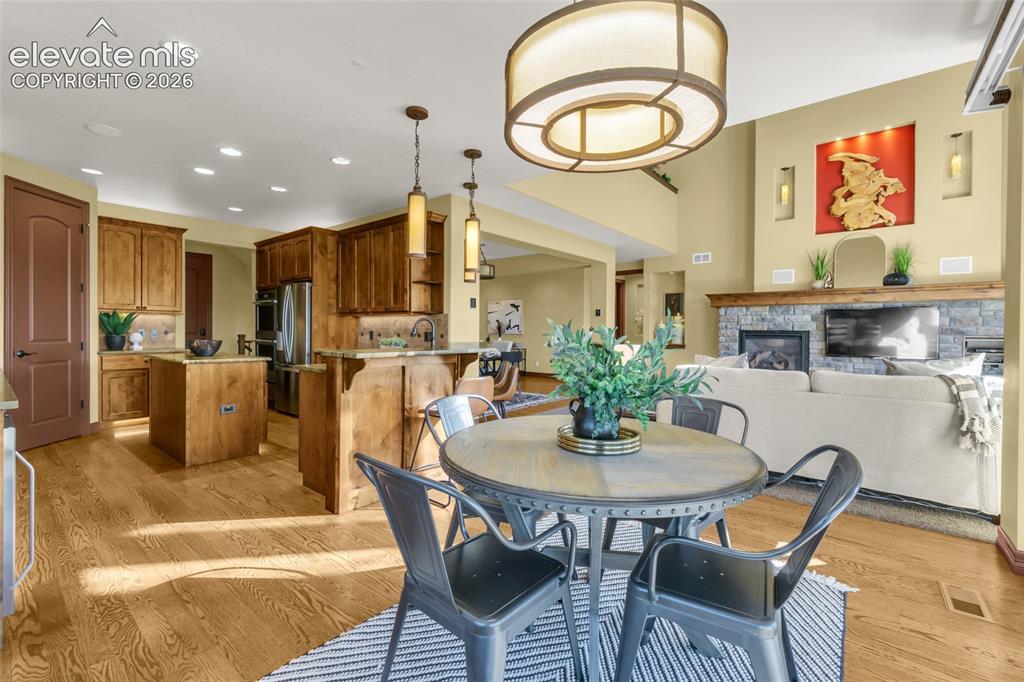 Image 32 of 50: Open-concept area featuring wood-finish flooring, custom cabinetry with a c