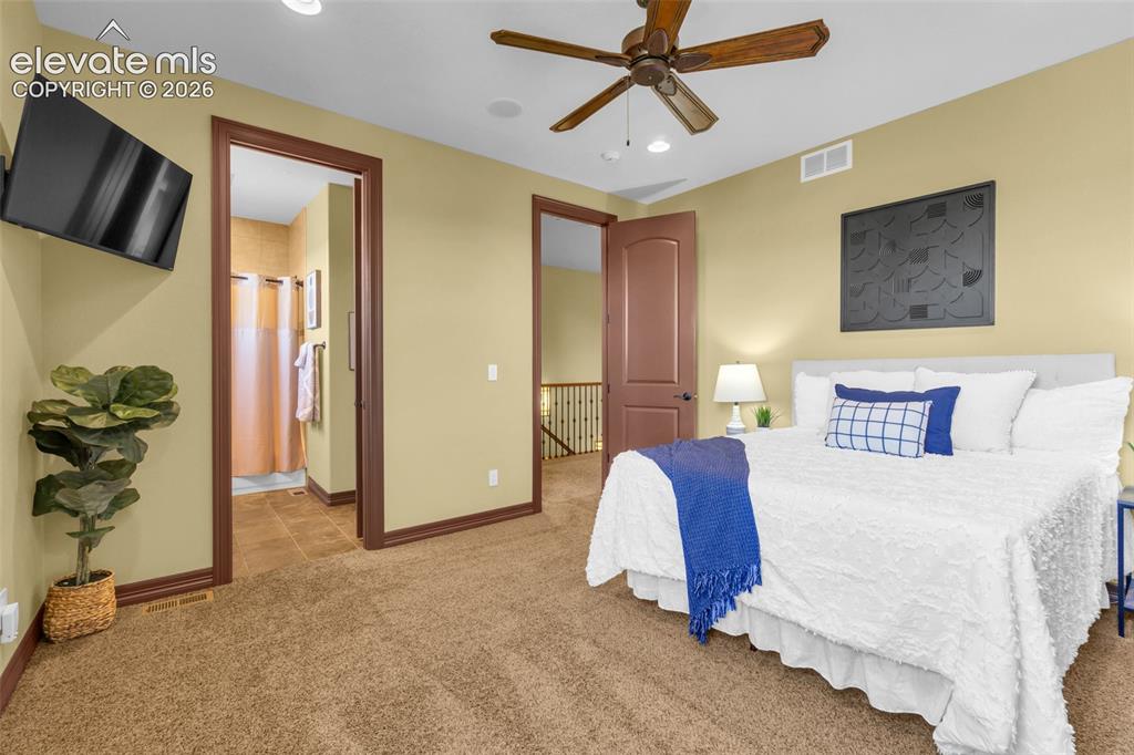Image 40 of 50: Carpeted bedroom featuring a wood-finish ceiling fan, recessed lighting, an