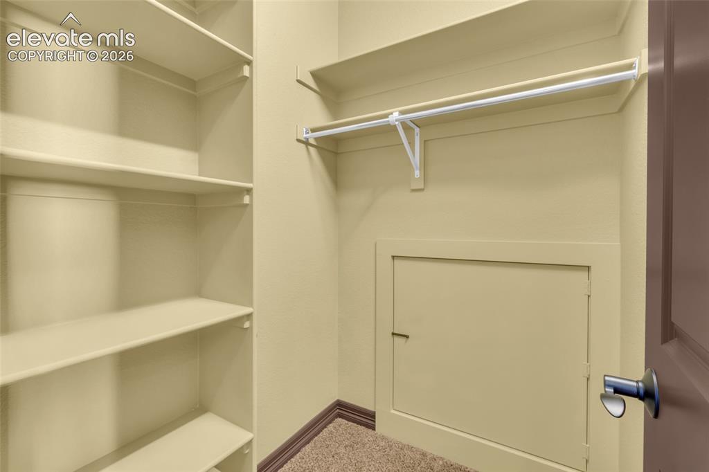 Image 44 of 50: Storage area featuring wall-to-wall built-in shelving, a full-width hanging