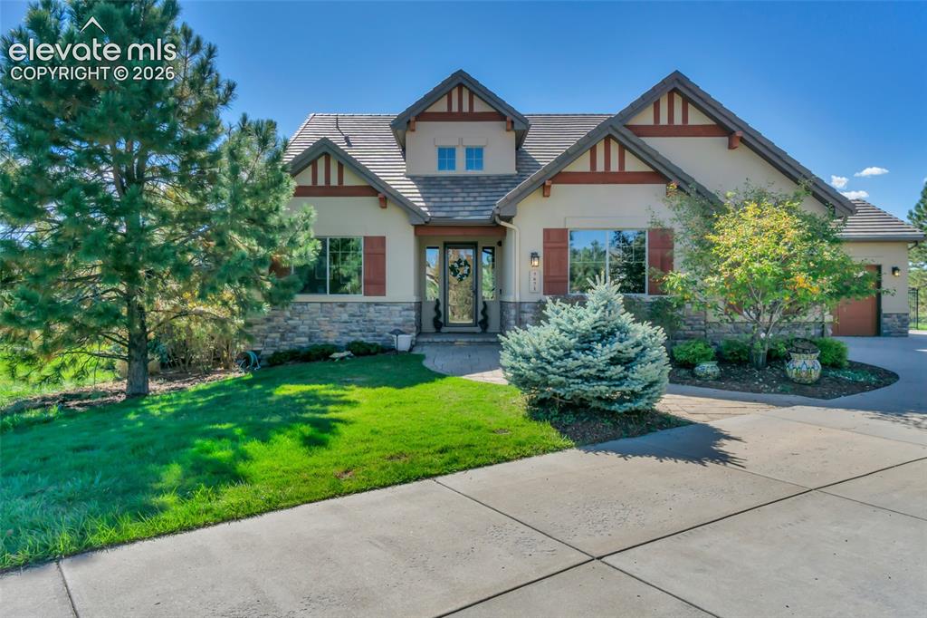Image 5 of 50: Exterior featuring a multi-gabled roofline, stone veneer foundation, stucco