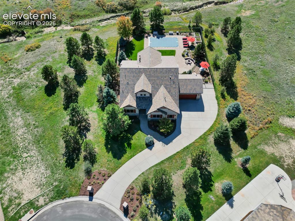 Image 6 of 50: Aerial view of residential property featuring a multi-gabled shingle roof,