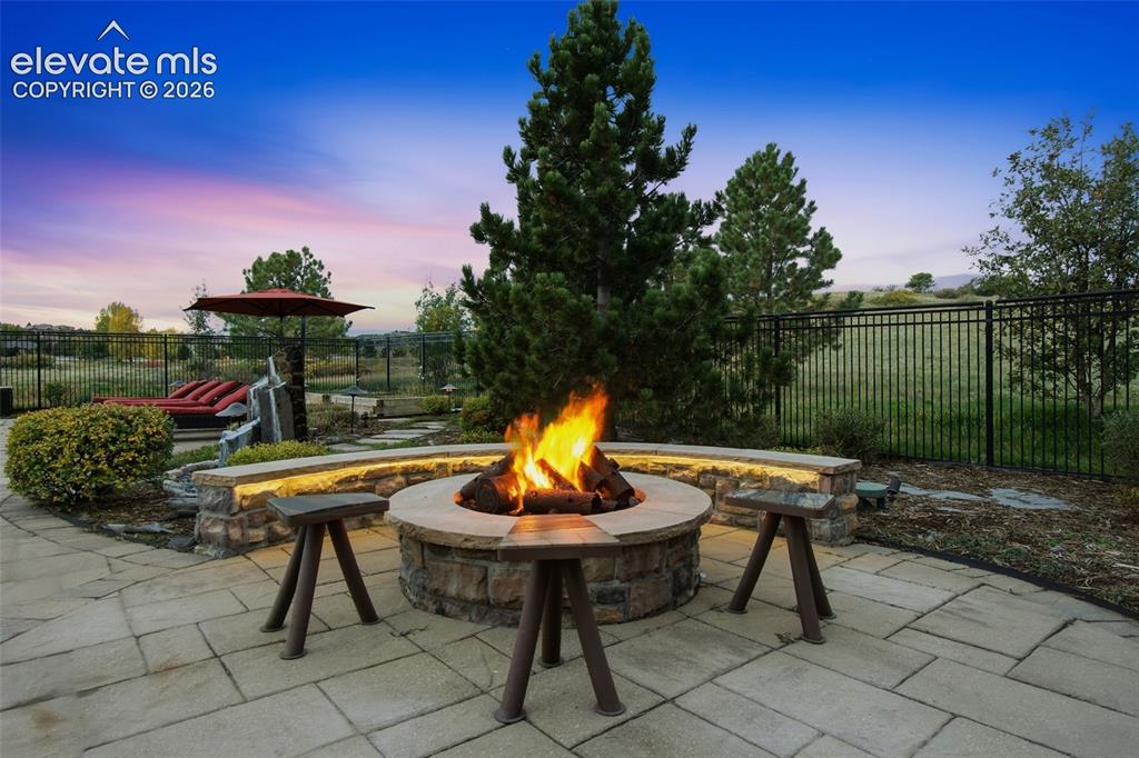 Image 8 of 50: Flagstone patio featuring a circular stone fire pit, curved stone seating w
