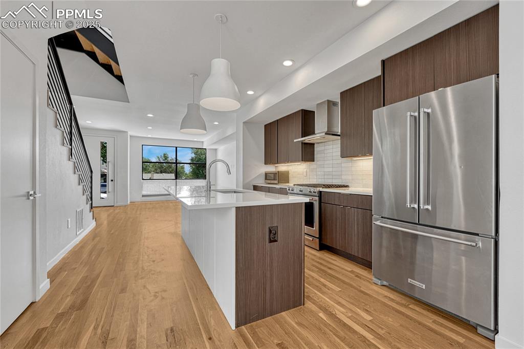 Image 10 of 49: Kitchen with appliances with stainless steel finishes, wall chimney range h