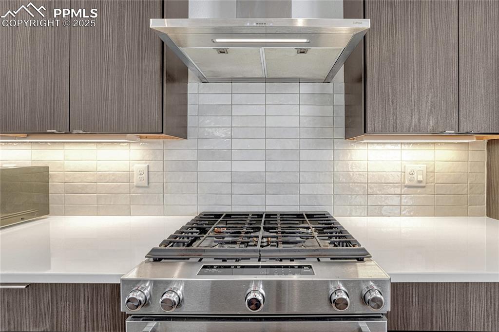 Image 13 of 49: Kitchen featuring stainless steel range with gas cooktop, ventilation hood,