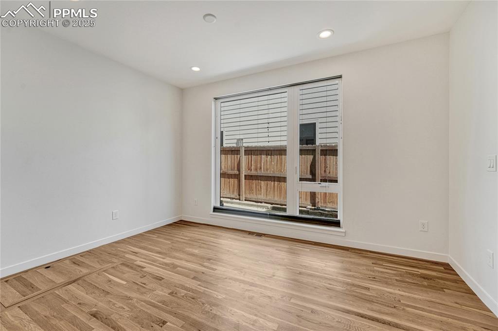 Image 15 of 49: Empty room featuring light wood finished floors and recessed lighting