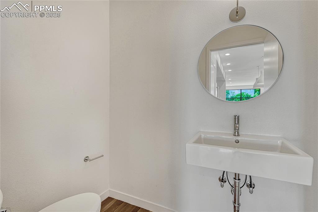Image 17 of 49: Half bath featuring toilet and wood finished floors