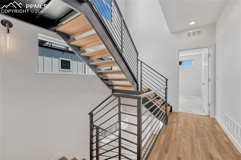 Image 18 of 49: Stairway featuring wood finished floors and recessed lighting