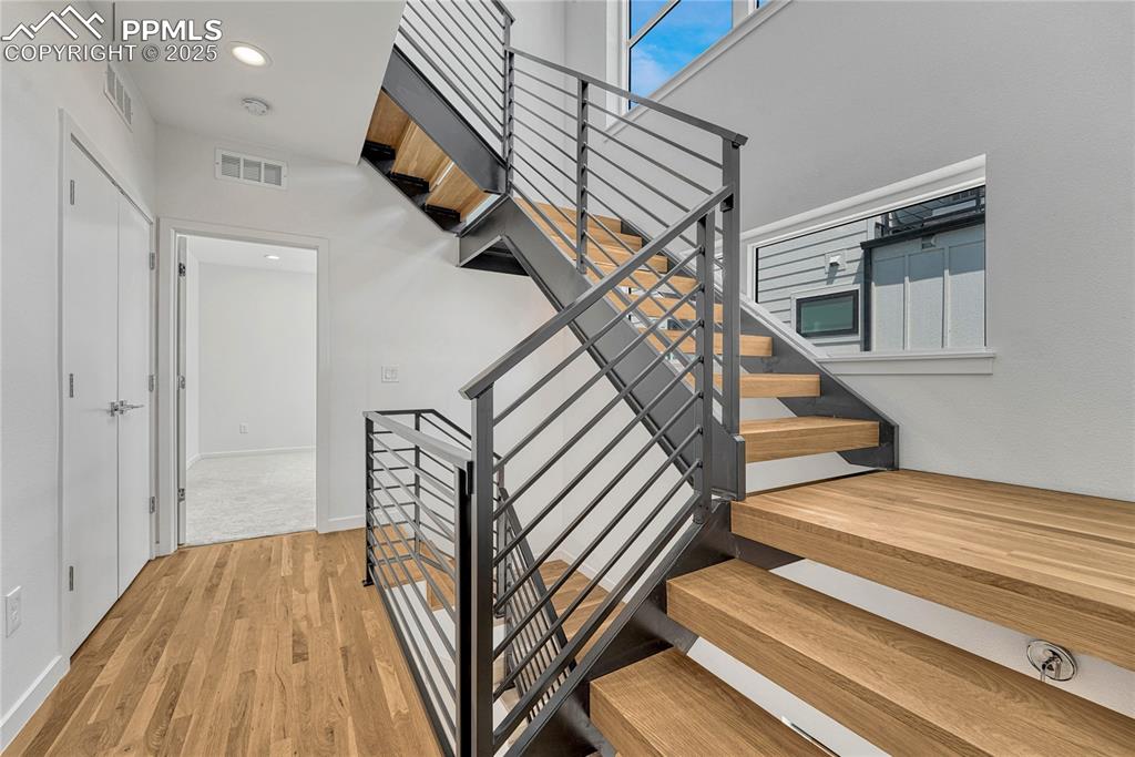 Image 19 of 49: Stairs featuring wood finished floors and recessed lighting