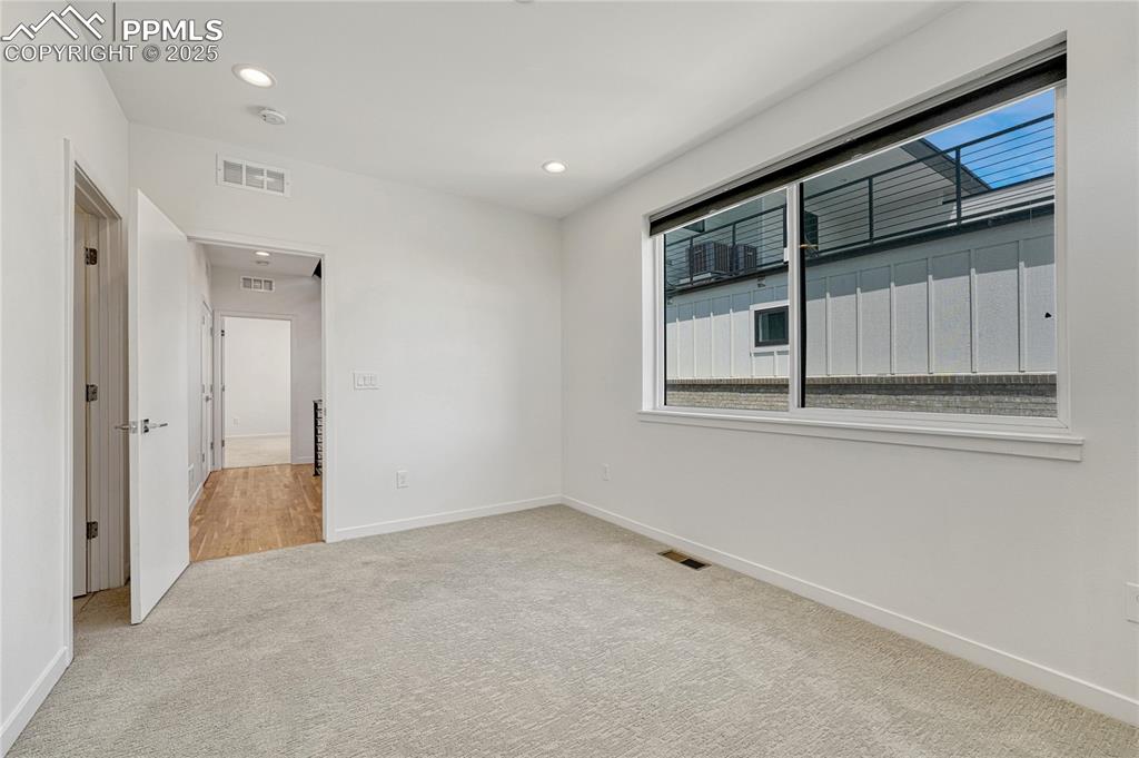 Image 22 of 49: Unfurnished room with carpet flooring and recessed lighting