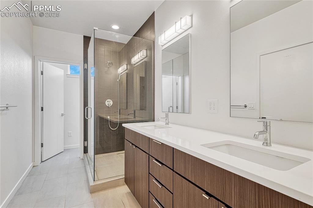 Image 23 of 49: Bathroom with a stall shower, double vanity, tile patterned floors, and rec