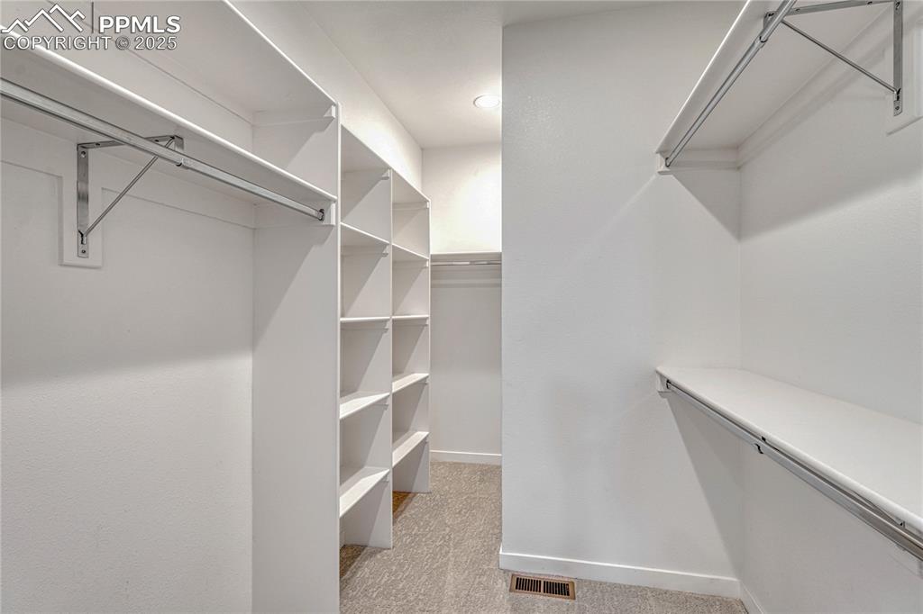 Image 25 of 49: Walk in closet with light colored carpet