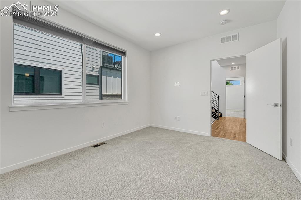 Image 27 of 49: Spare room with carpet flooring, recessed lighting, stairway, and a smoke d