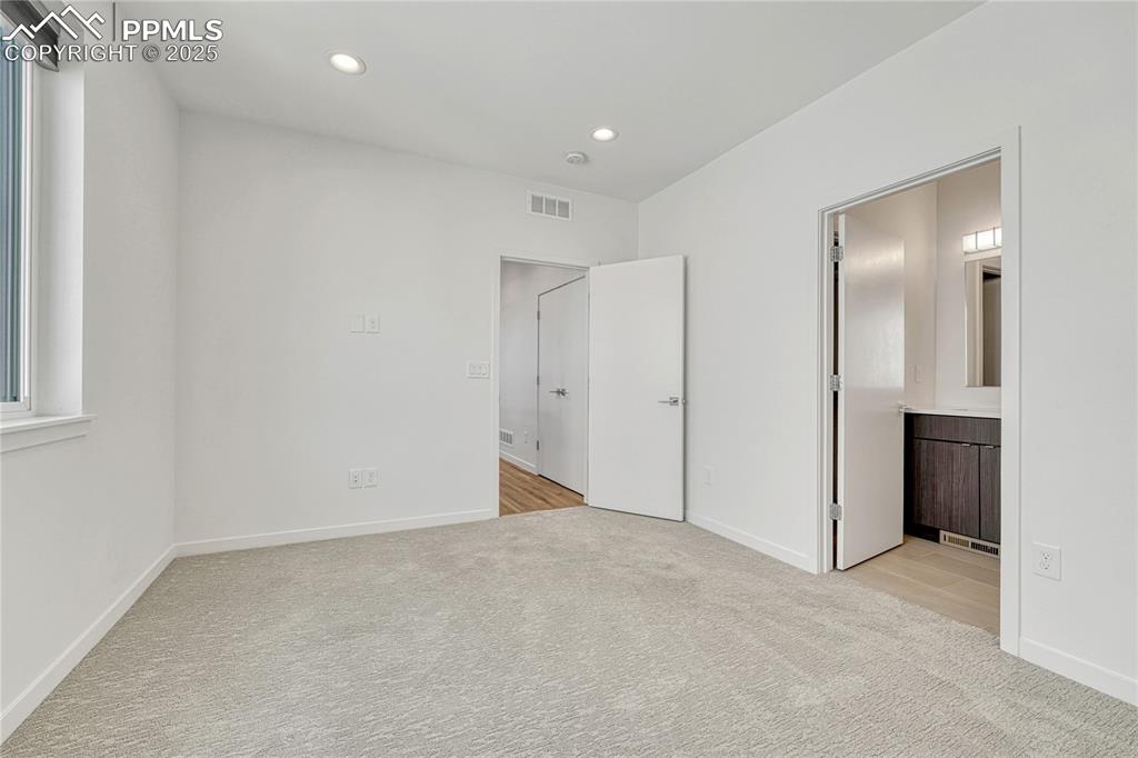 Image 28 of 49: Unfurnished bedroom featuring light colored carpet, recessed lighting, and