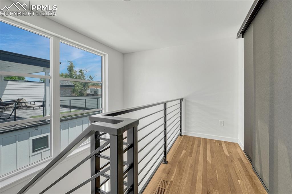 Image 32 of 49: Hallway featuring an upstairs landing and light wood-style flooring