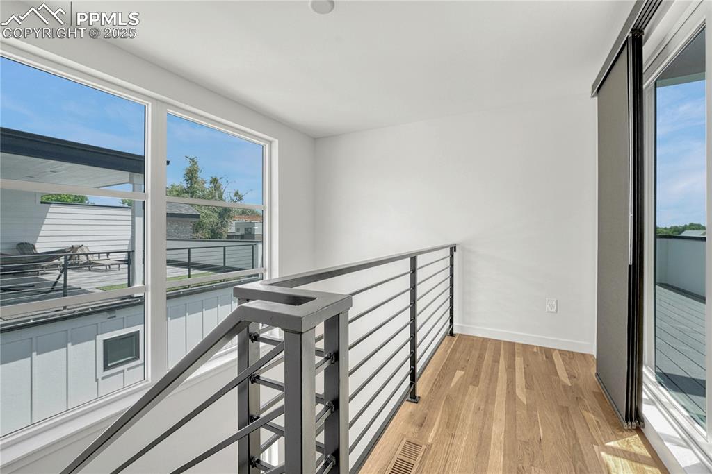 Image 33 of 49: Hall featuring light wood-style floors and an upstairs landing