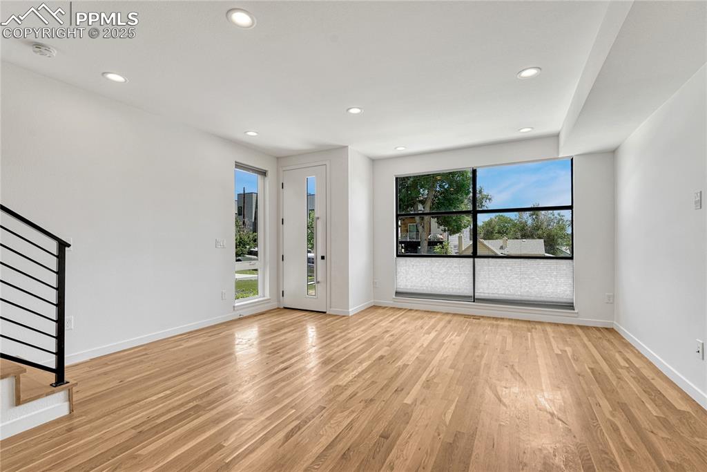 Image 5 of 49: Unfurnished room with stairs, light wood-type flooring, recessed lighting,