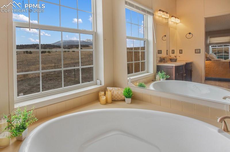 Image 20 of 32: Full bathroom featuring a bath, a mountain view, and vanity