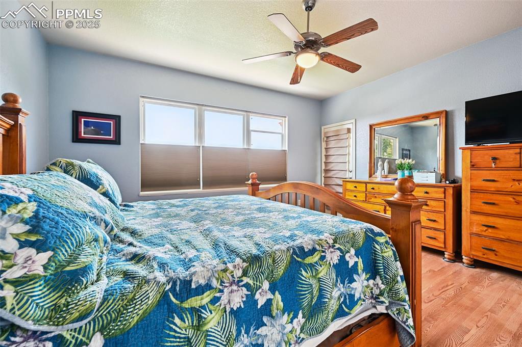 Image 20 of 45: Bedroom with light wood-type flooring, a ceiling fan, and a textured ceilin