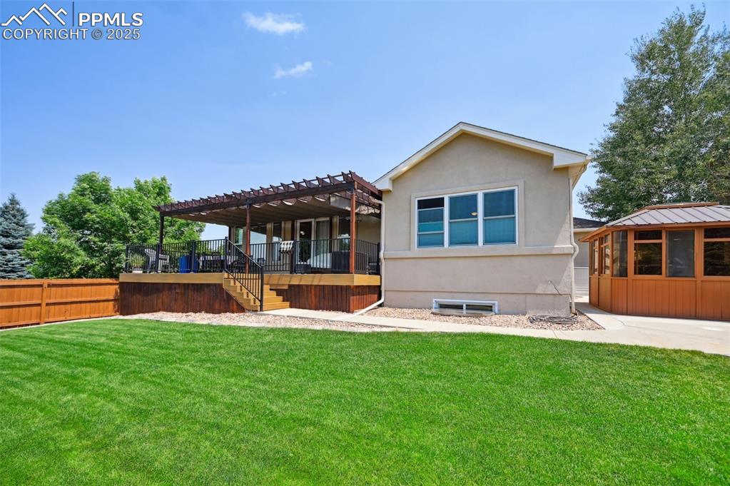 Image 42 of 45: Rear view of property featuring a pergola, stucco siding, and stairs