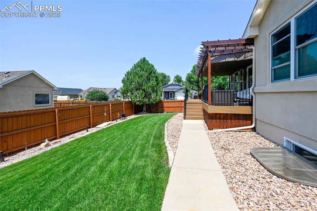 Image 45 of 45: Fenced backyard featuring a wooden deck and a pergola