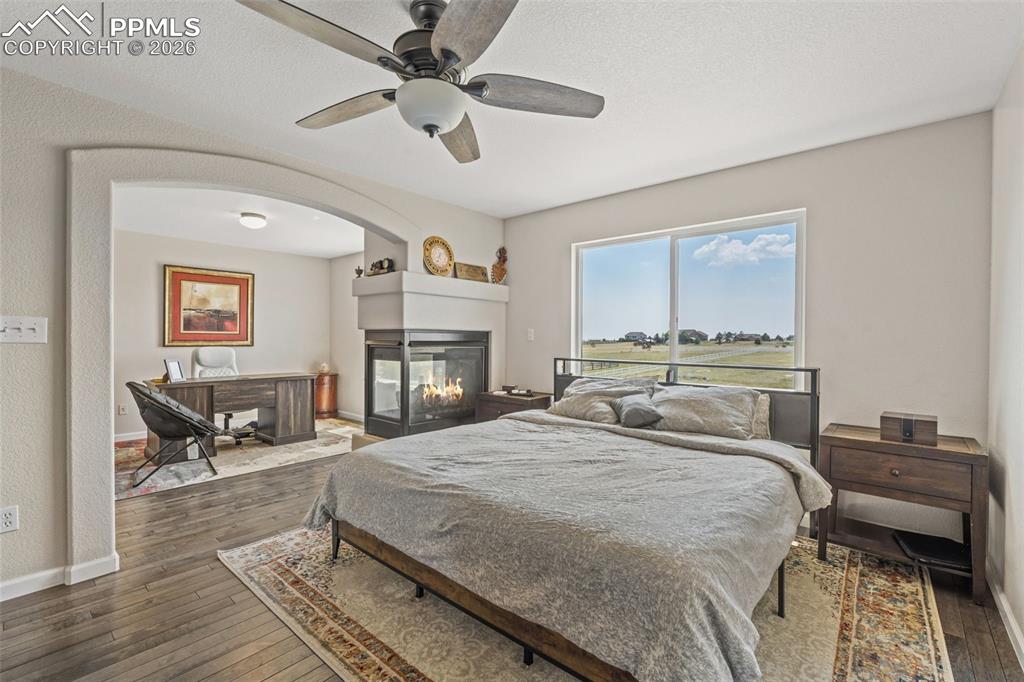 Image 21 of 47: Bedroom featuring dark wood-style flooring, a ceiling fan, a desk, and a mu