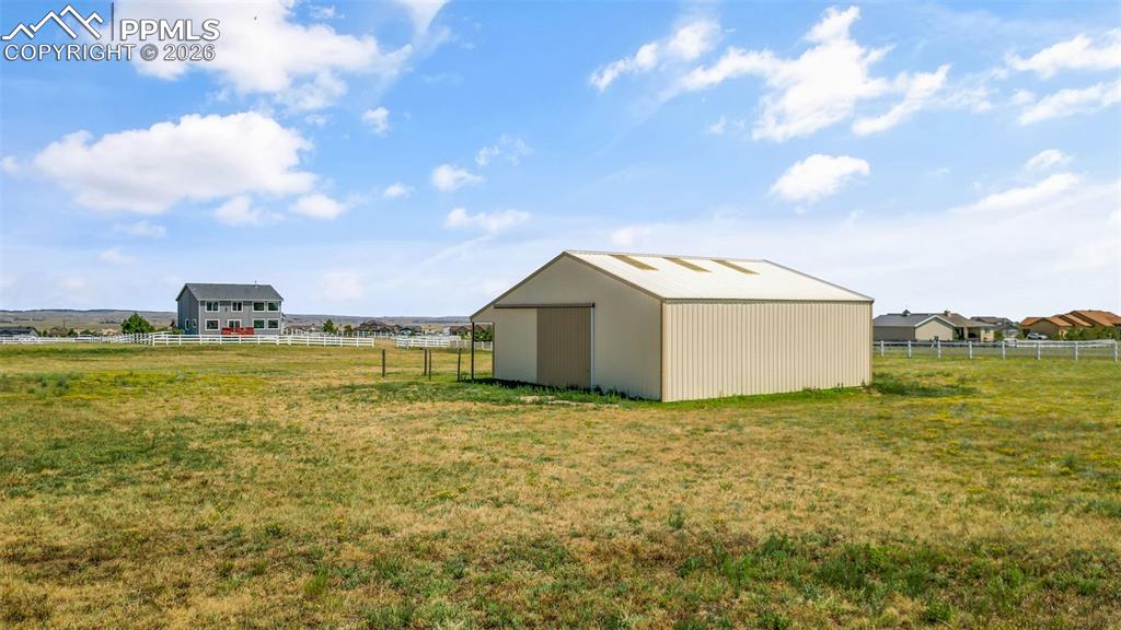 Image 36 of 47: View of yard featuring an outdoor structure, an outbuilding, and a view of 