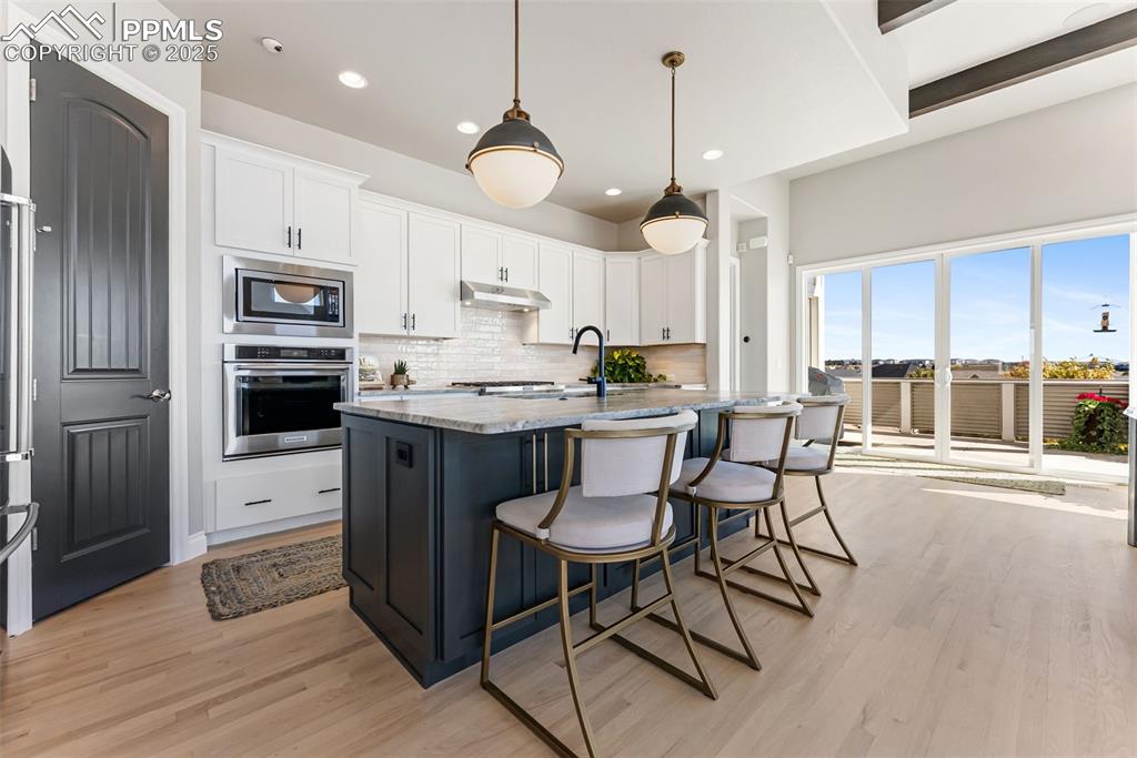 Image 15 of 50: Kitchen offers clean finishes and updated cabinets and backsplash. Built-in